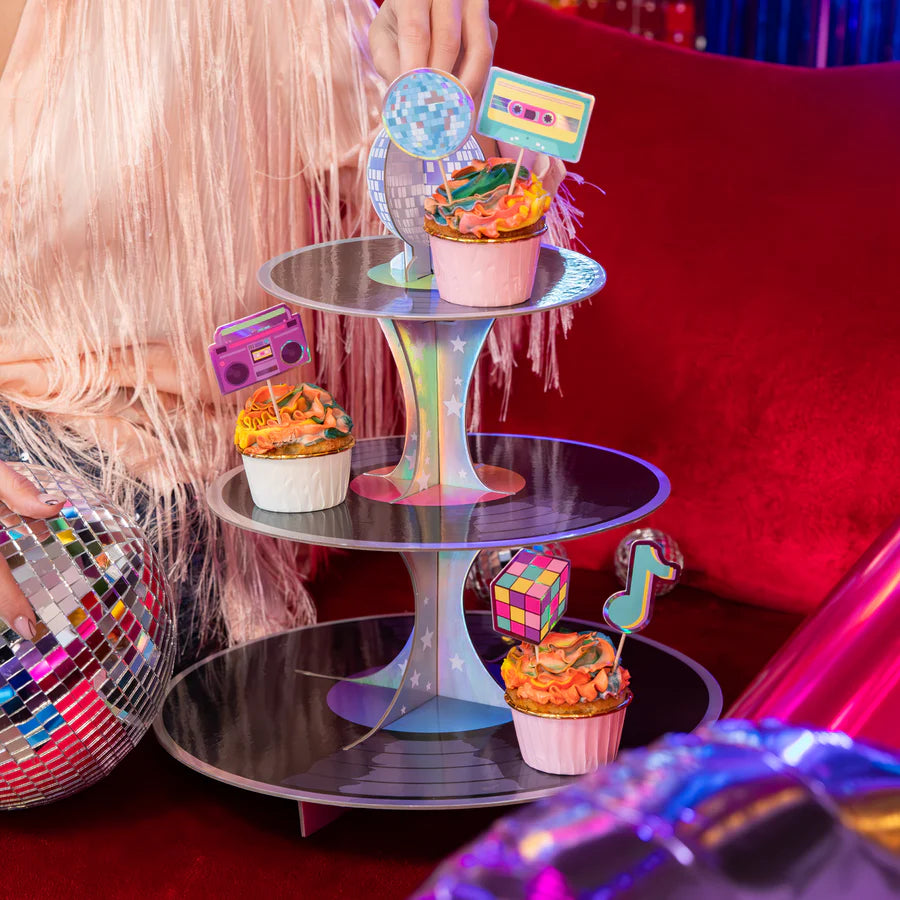 Retro disco paper cupcake stand displaying colorful cupcakes, 34x39 cm, with vibrant accessories and a festive background.