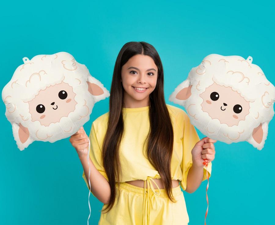 Girl holding two 43x36 cm foil sheep balloons against a blue background, perfect for parties and celebrations.