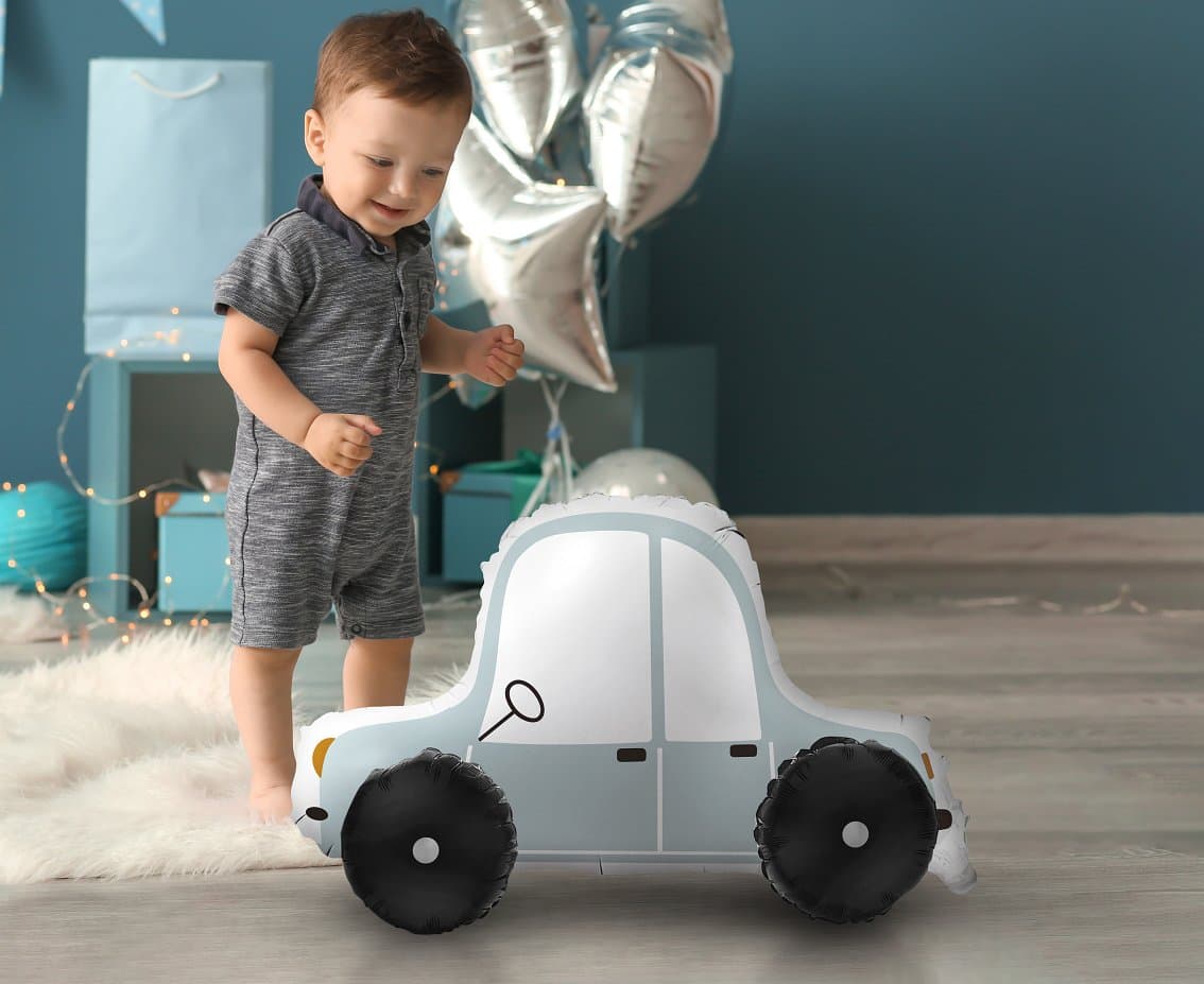 Child playing with a 3D foil balloon car in a festive room with balloons and decorations, measuring 72x43x42 cm.