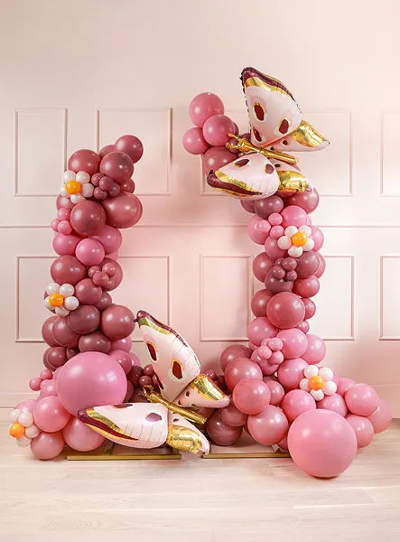 Decorative balloon arch with pastel pink and rose balloons, featuring butterfly designs and floral accents.
