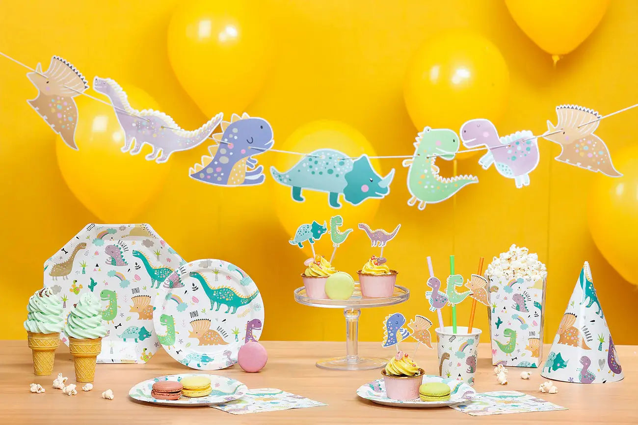 Colorful dinosaur-themed birthday party setup with balloons, plates, and festive treats.