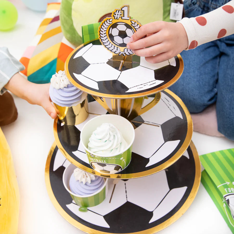 A colorful paper cupcake stand shaped like a football, holding cupcakes, perfect for sports-themed celebrations and parties.