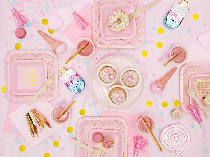 Colorful pink party setup with desserts, plates, and playful decor, perfect for celebrations and special occasions.