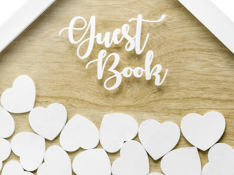 Wooden guest book in house shape with white hearts for signing, perfect for events and weddings.